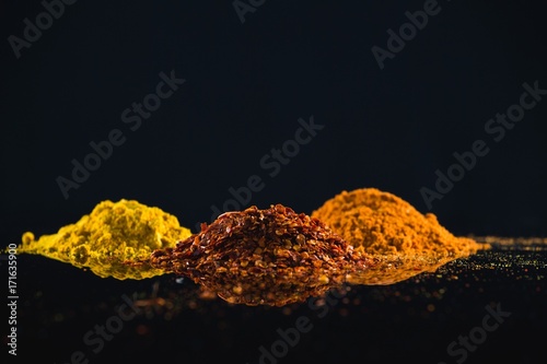 Fototapeta Naklejka Na Ścianę i Meble -  Powdered spices against black background