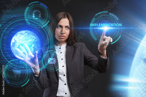 The concept of business, technology, the Internet and the network. A young entrepreneur working on a virtual screen of the future and sees the inscription: Implementation