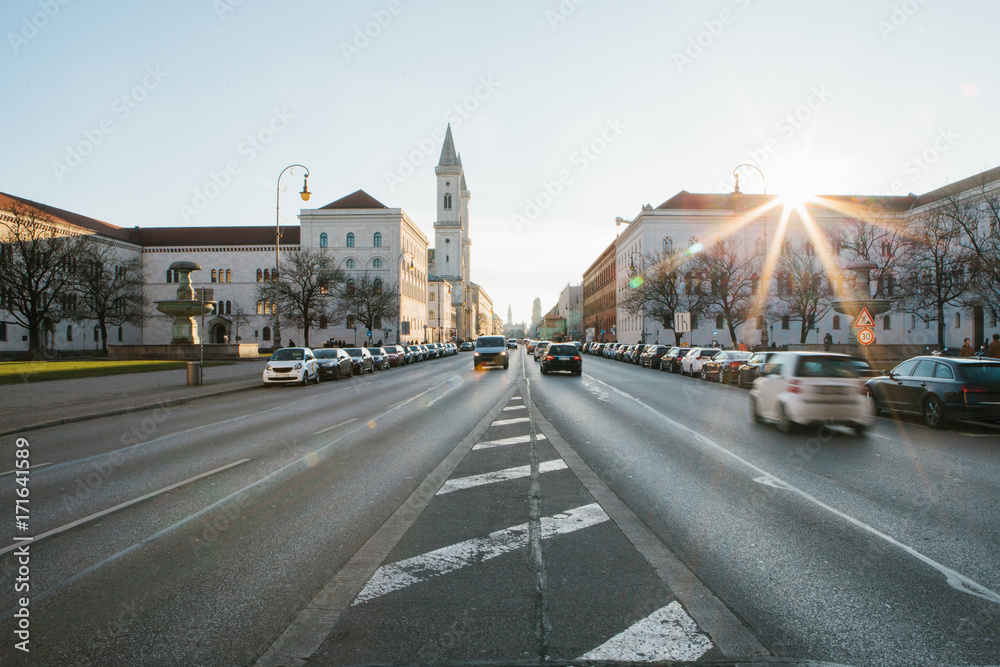 View of the road on the street Leopoldstrasse in Munich. Germany. Fast blurred motion car on sunset background.