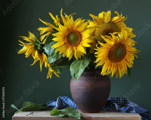 Bouquet of sunflowers in a clay jug.