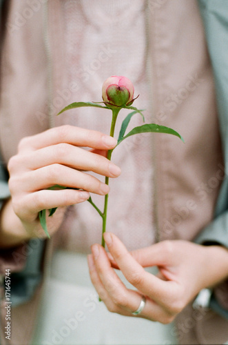 Woman holding peony's bud
