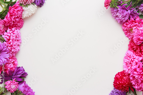 Spring flowers. Pink flowers on white wooden background. Flat lay, top view. photo