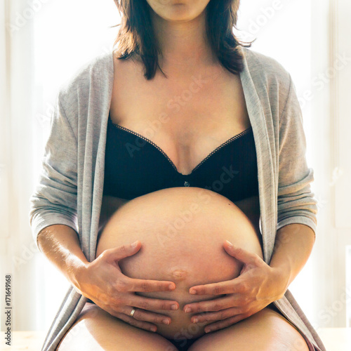 Pregnant woman touching belly photo