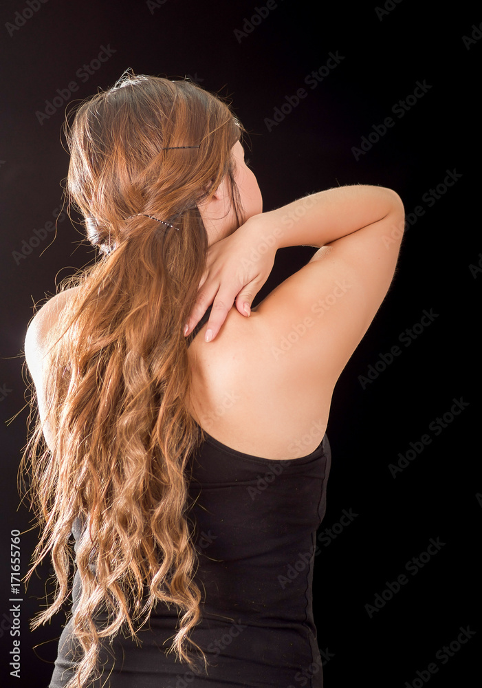 Fototapeta premium Beautiful young lady Suffer crick after workout in a black background