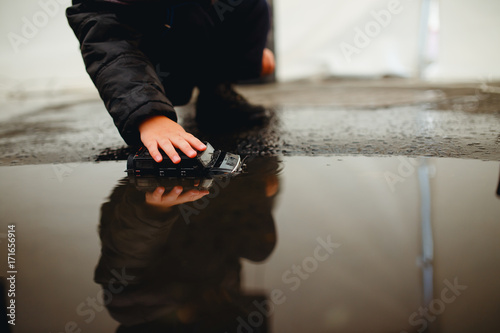 Houston, Texas - August 27, 2017: child plays with toys in a puddle of water. Heavy rains from hurricane Harvey. photo