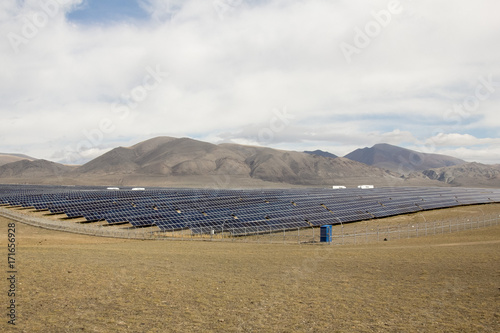 solar farm in the mountains under the cloudy sky