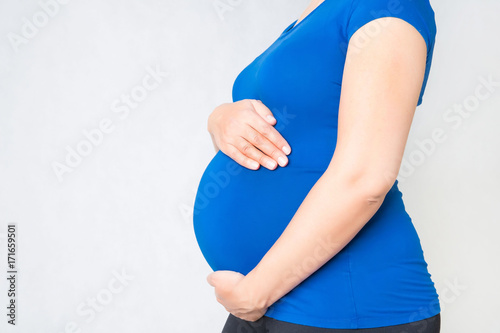 pregnant woman holding hands on her belly