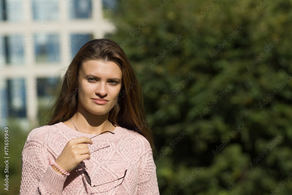 Young cute woman holding glasses in hands. Girl in stylish urban casual clothes. Early Autumn Young cute woman holding glasses in hands. Girl in stylish urban casual clothes. Early Autumn