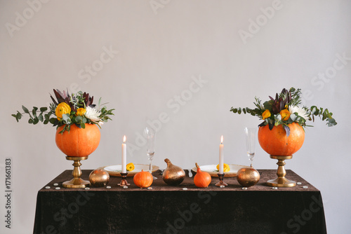 Fototapeta Naklejka Na Ścianę i Meble -  autumn floral bouquet in a pumpkin vase for Halloween. Table setting for wedding