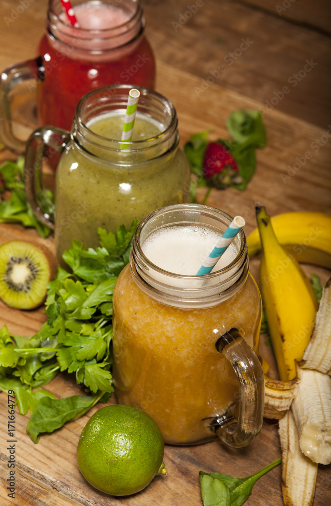 Assortment of fruit and vegetable smoothies in glass jars with straws Assortment of fruit and vegetable smoothies in glass jars with straws