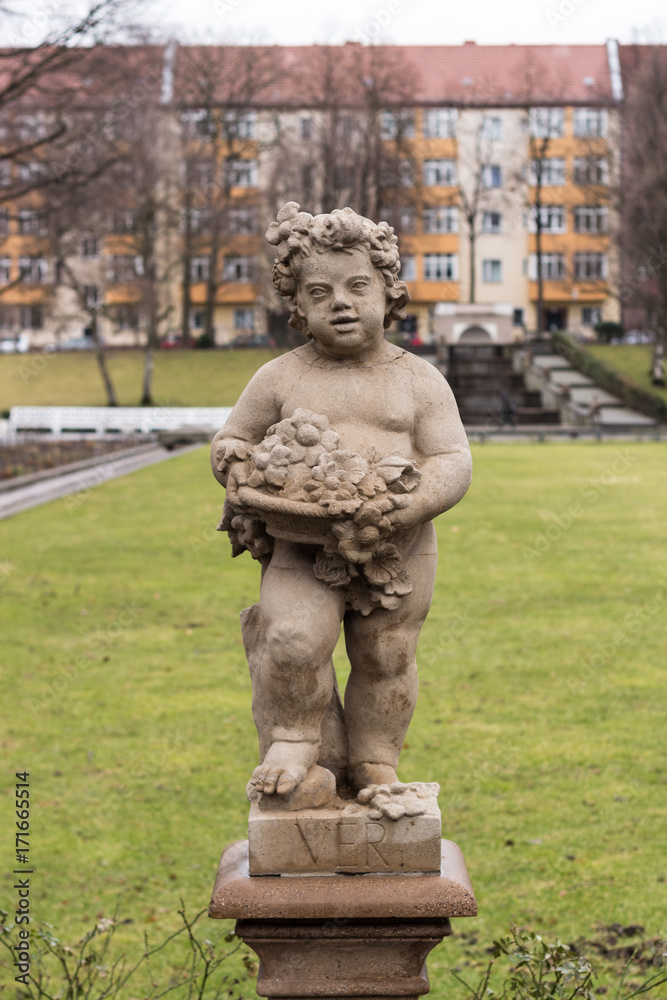 Obraz premium Portrait of a statue of a boy carrying flowers in the Public Koernerpark in Berlin Neukoell (ca 1914)