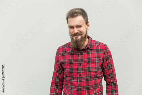 Flirt and wink. Carefree bearded man winked at camera and smiling