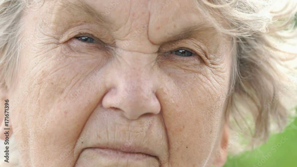 Portrait of serious mature elderly woman with gray hair outdoors in summer. Close-up Portrait of serious mature elderly woman with gray hair outdoors in summer. Close-up