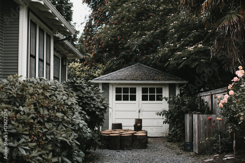 Garage next to house surrounded by greenery