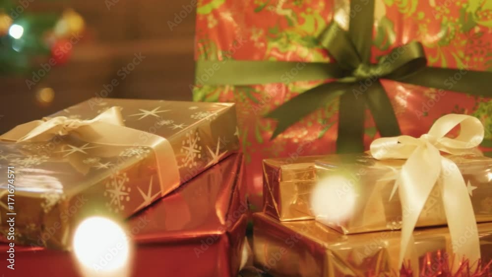 Close-up tracking shot of beautiful presents under the Christmas tree.
