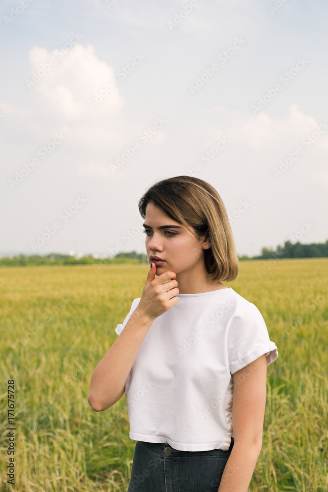 Pensive young blonde girl with finger at lips Pensive young blonde girl with finger at lips