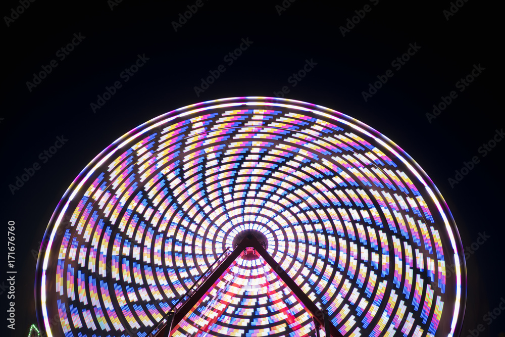 Spinning ferris wheel at night, abstract
