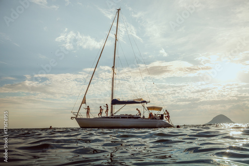 A group of young tourists lounge on a sailboat in Brazil