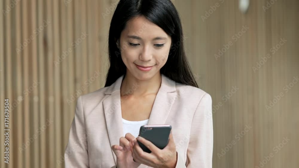Business woman walking in the building and using cellphone Business woman walking in the building and using cellphone