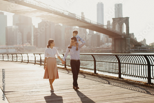 Young family walking near Brooklyn Bridge, New York, USA photo