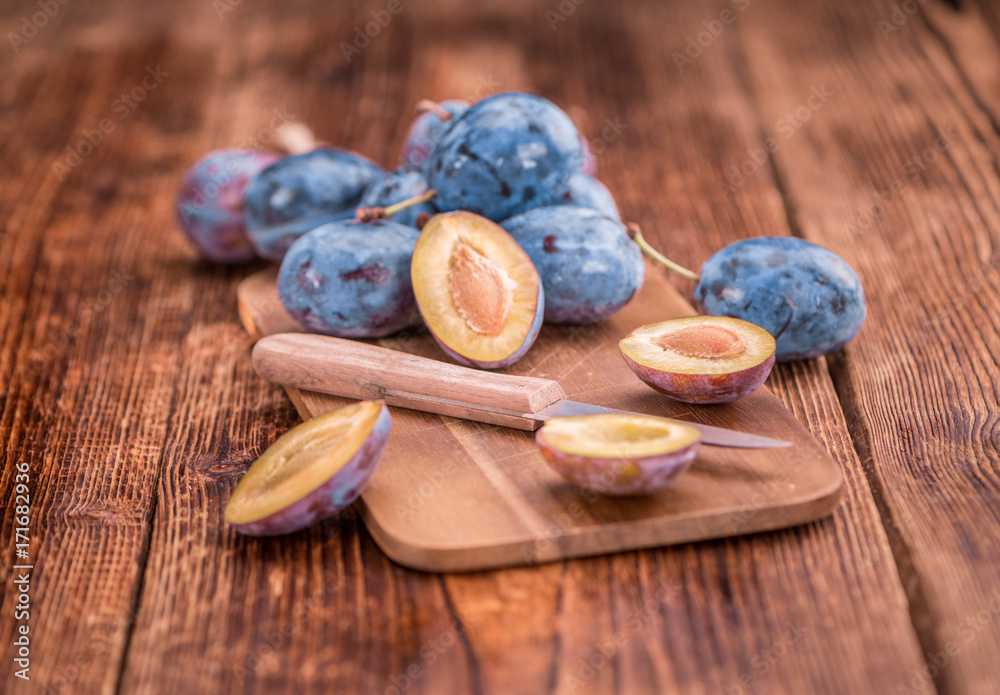 Portion of Plums on wooden background, selective focus