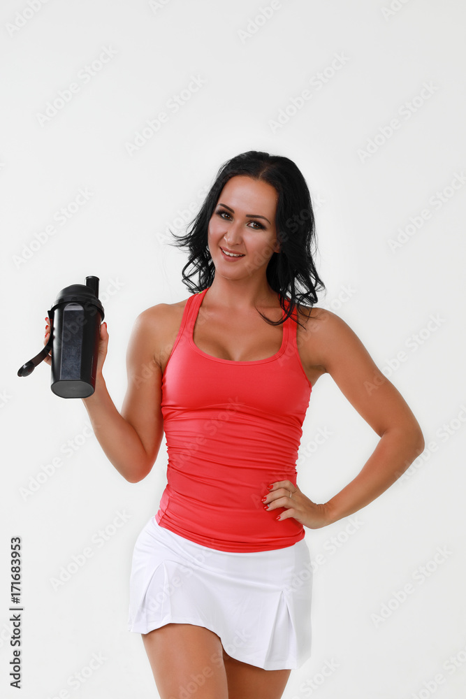 Young woman with protein shake bottle on white background