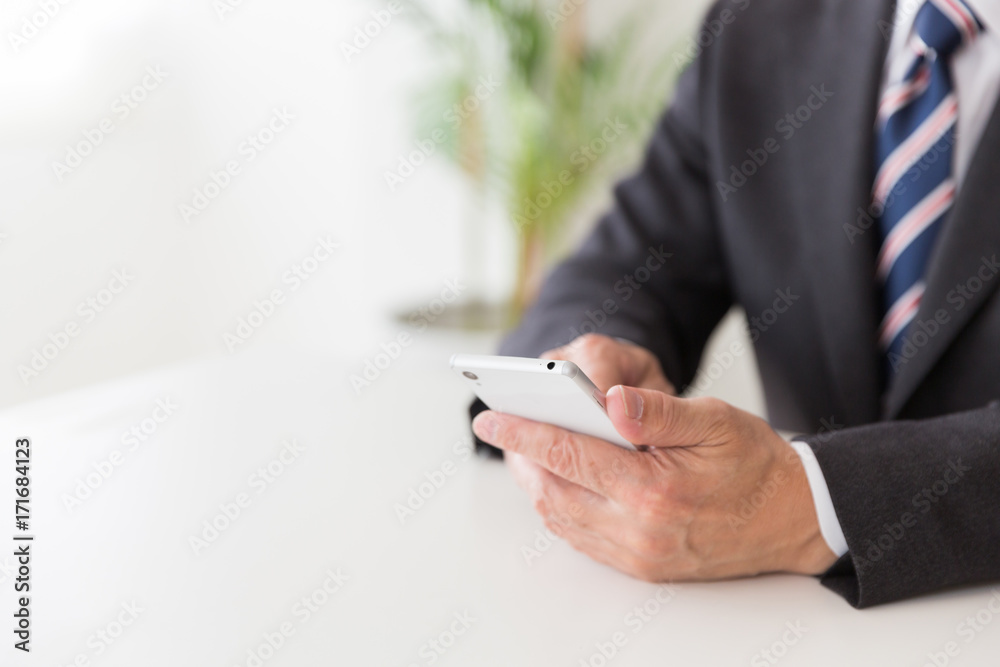 スマホを持つミドル男性 手元 ビジネス スマホを持つミドル男性 手元 ビジネス