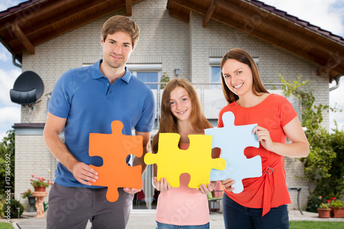 Happy Family Holding Colorful Jigsaw Puzzles