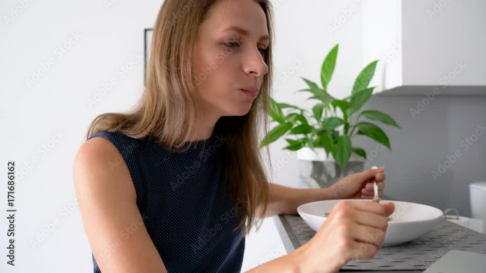 Attractive woman using her laptop while having a breakfast Attractive woman using her laptop while having a breakfast