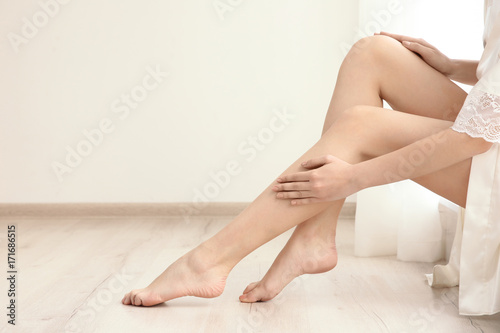 Woman with beautiful legs sitting on window sill in room