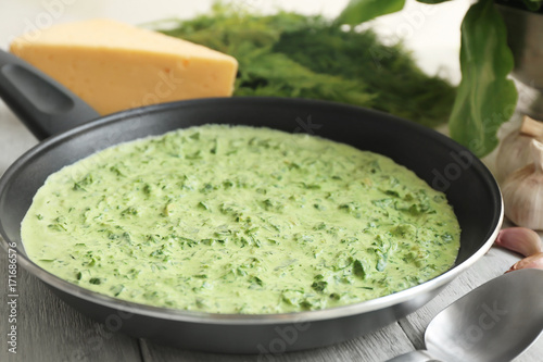 Frying pan with spinach dip on table