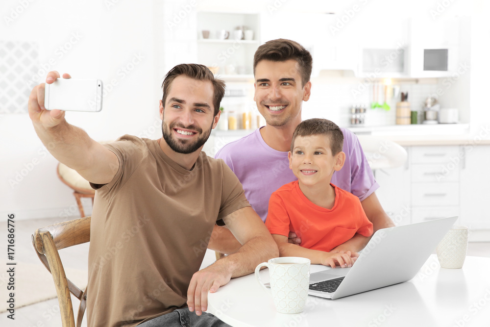 Fototapeta premium Male gay couple with foster son taking selfie. Adoption concept