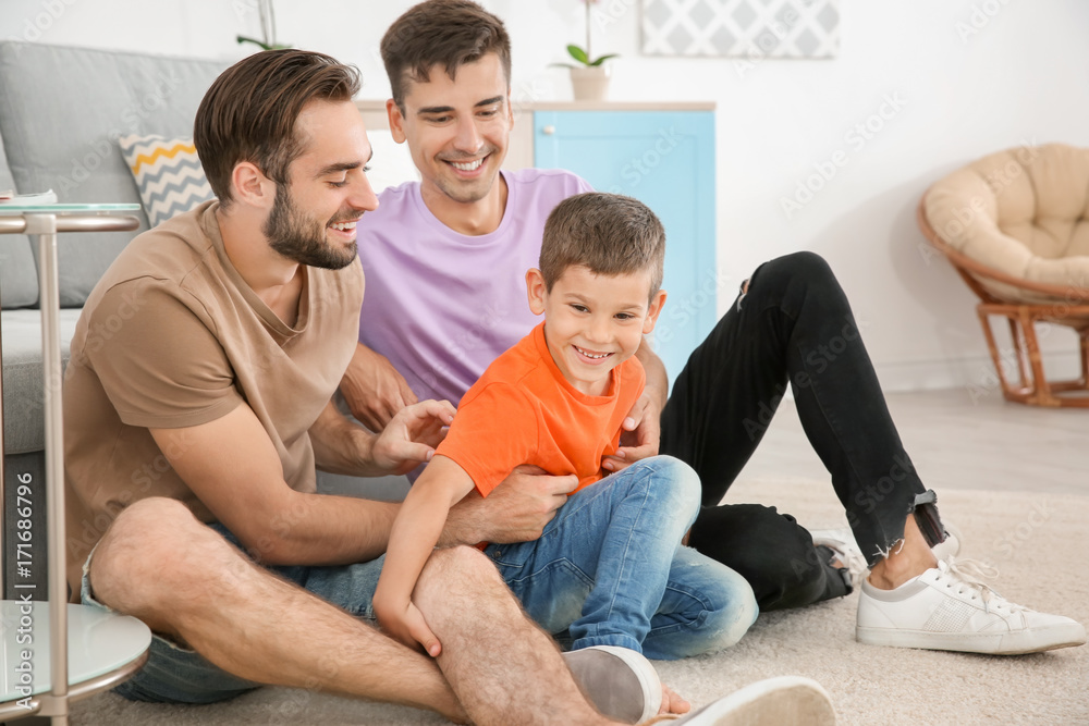 Homosexual male couple with foster son at home. Adoption concept