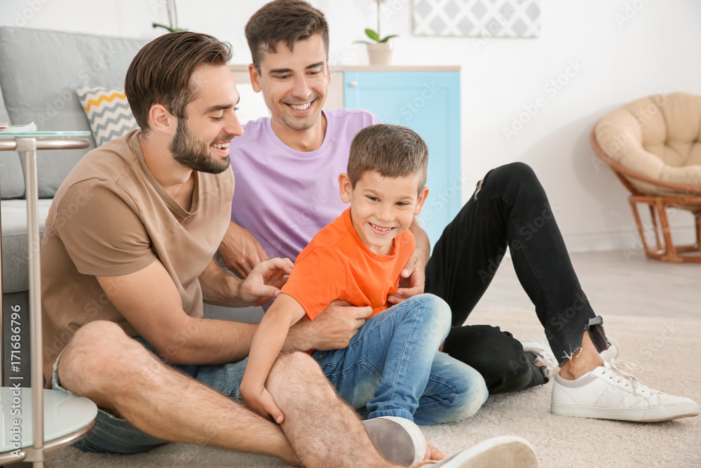 Homosexual male couple with foster son at home. Adoption concept Homosexual male couple with foster son at home. Adoption concept