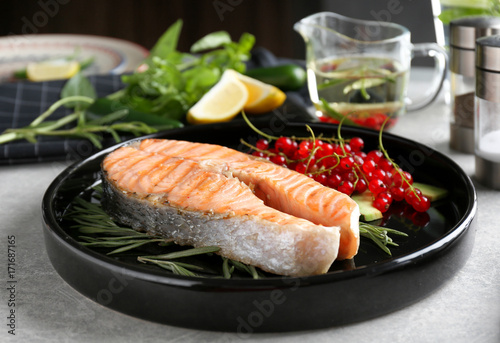 Grilled salmon steak with rosemary and red currant on plate