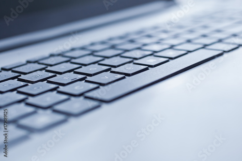 Laptop keyboard closeup in blue tones