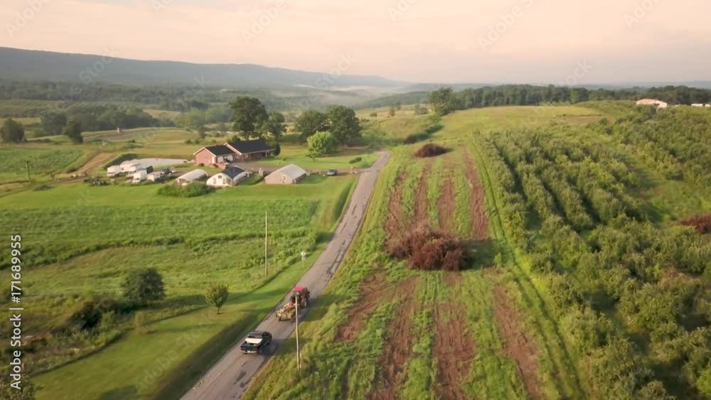 Aerial view of following tractor down country road in the rolling hills of West Virginia. Aerial view of following tractor down country road in the rolling hills of West Virginia.