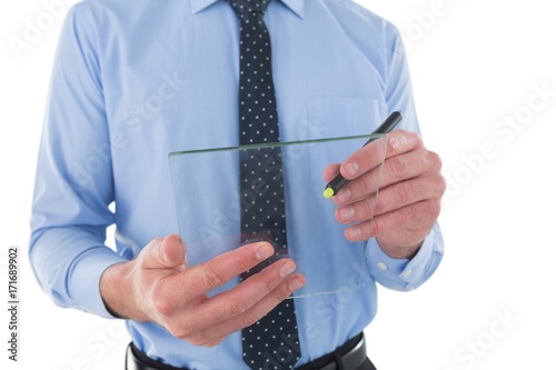 Mid section of businessman writing on glass interface