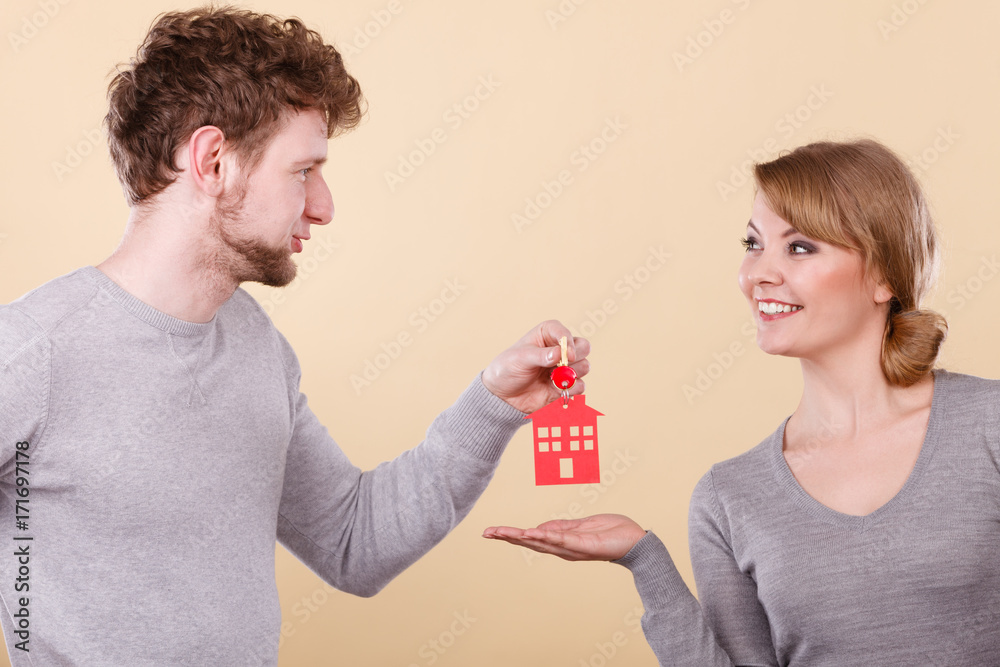 Couple holding key with house symbol Couple holding key with house symbol