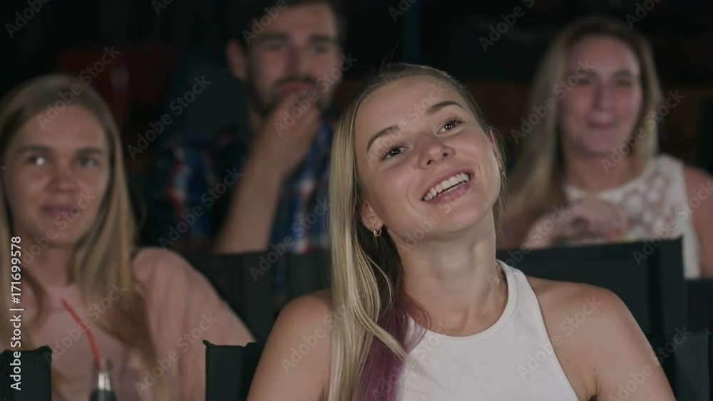 Happy friends watching comedy movie in theater Happy friends watching comedy movie in theater