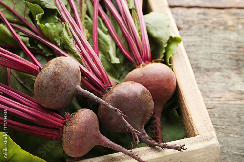 Fresh and ripe beets in crate on wooden table