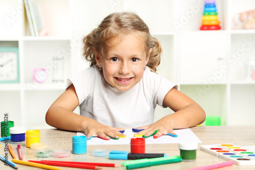 Beautiful little girl with colourful painted hands