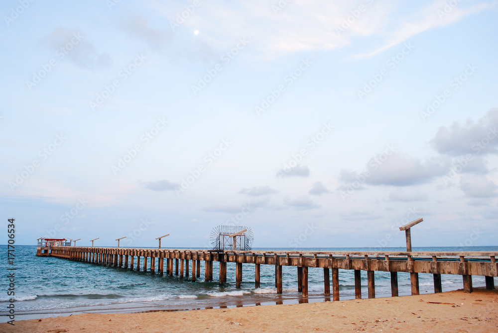 Jetty or wooden boardwalk on the beach travel background.