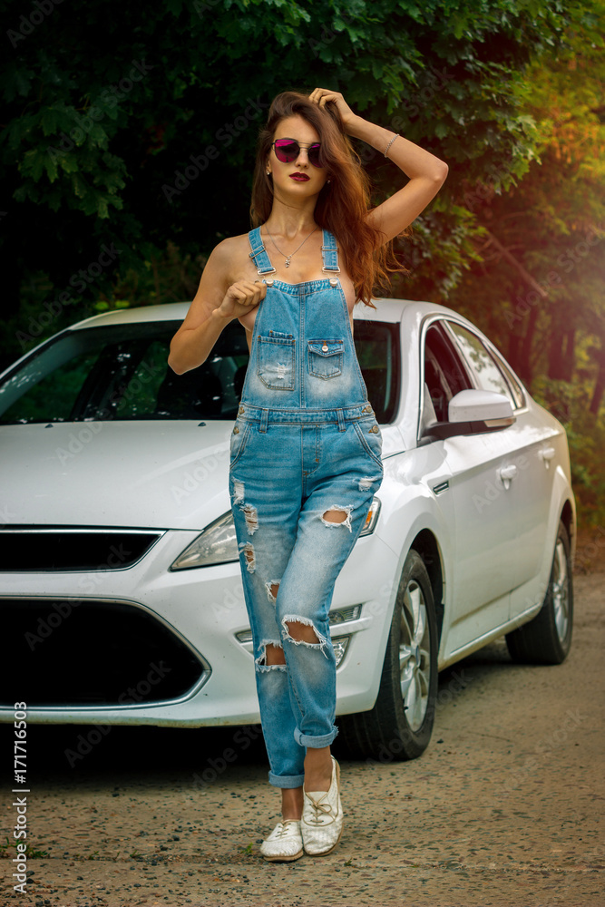 Handsome young lady with big silicon boobs wears a jeans overall on naked  body Stock Photo | Adobe Stock