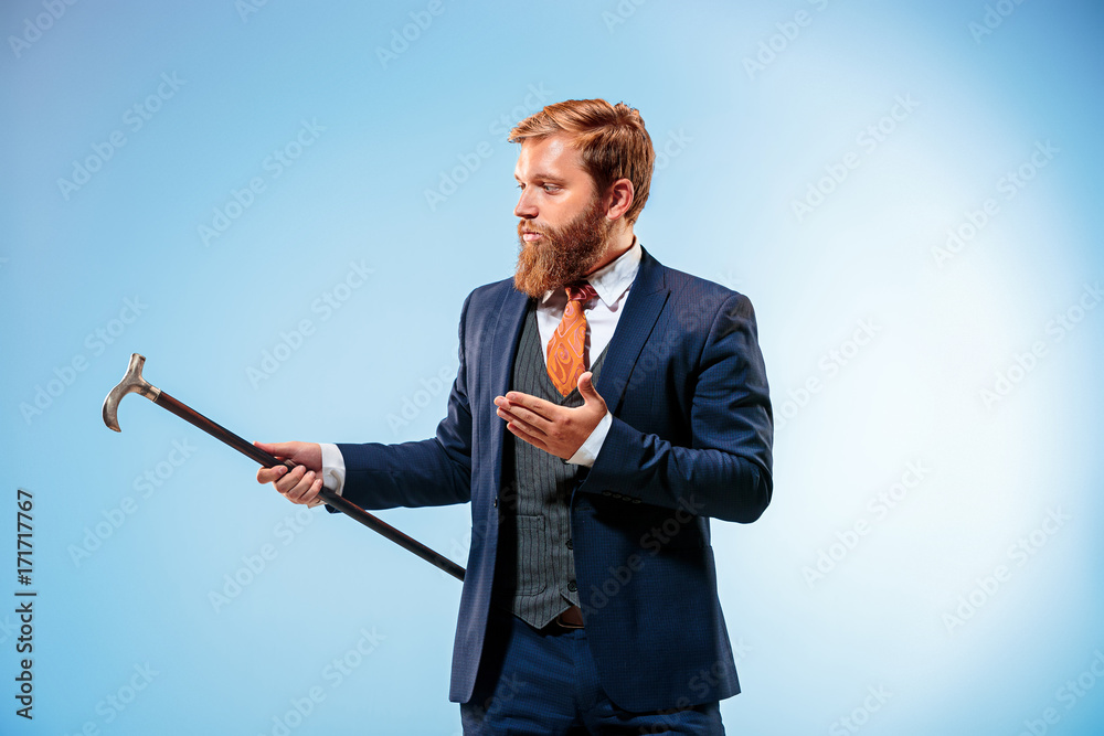 The barded man in a suit holding cane. The barded man in a suit holding cane.