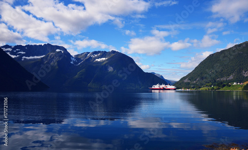 Hjorundfjord, Norway, September 2nd, 2017: Hurtigruten Cruise Ship in Fjord on a beautiful summer day