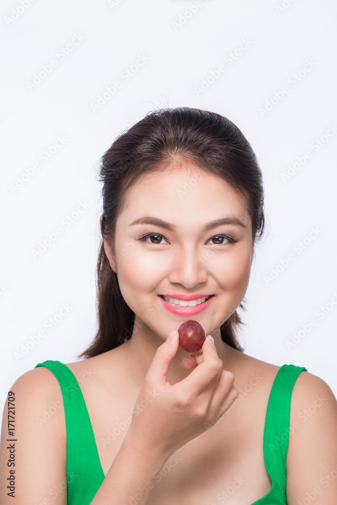 Young beautiful asian woman eating fresh grapes isolated on white background Young beautiful asian woman eating fresh grapes isolated on white background