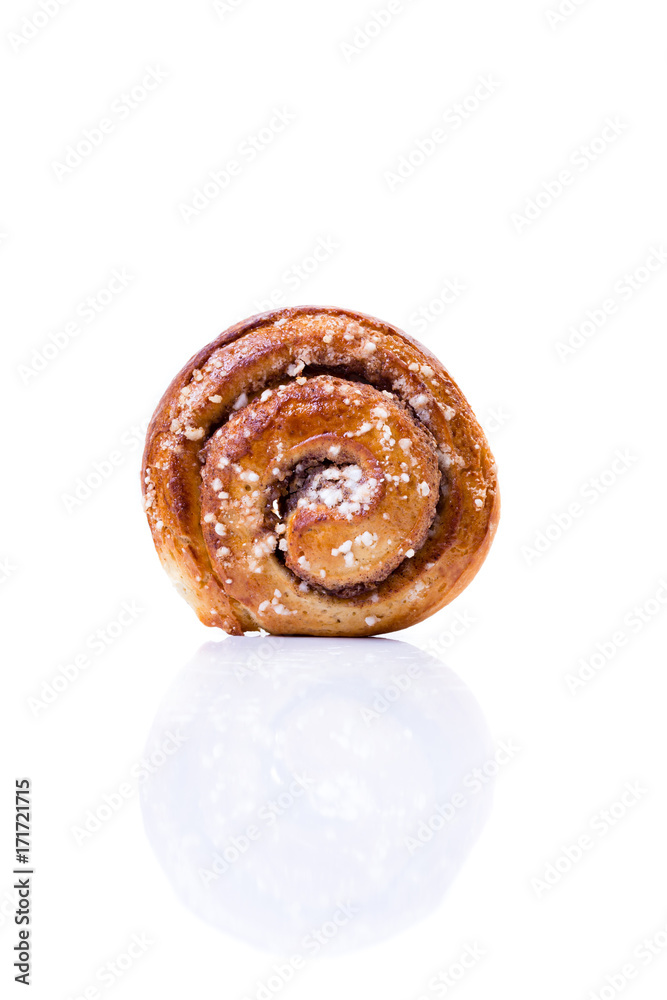 en kanelbulle isolerat mot vit bakgrund med spegling i högglans bordet, stående framifrån en kanelbulle isolerat mot vit bakgrund med spegling i högglans bordet, stående framifrån