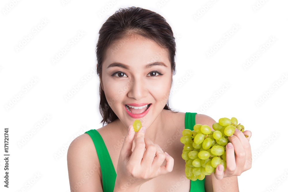 Young beautiful asian woman eating fresh grapes isolated on white background Young beautiful asian woman eating fresh grapes isolated on white background