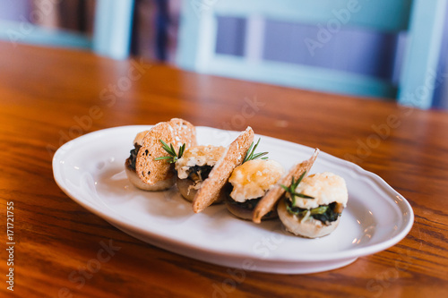 The close-up side photo of the food composition consisted of the mushrooms, cheese and dried bread.